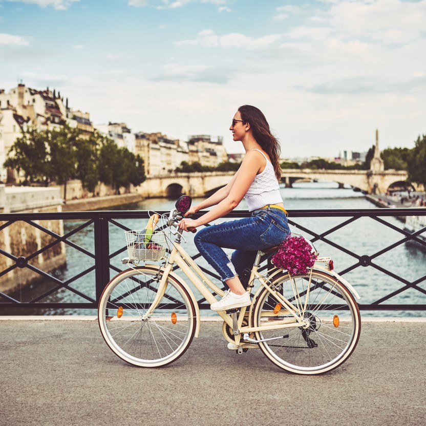 young woman touring the city of Paris with a bicycle