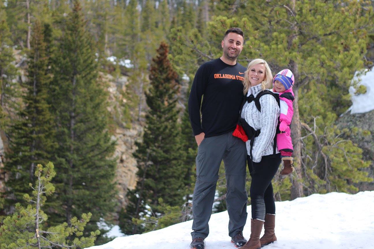 Nick and Brittany Garcia with their daughter at a snowy landscape
