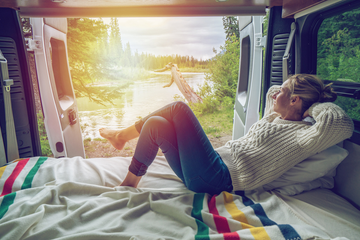 Young woman having a stunning view out of the back of her Camping Van