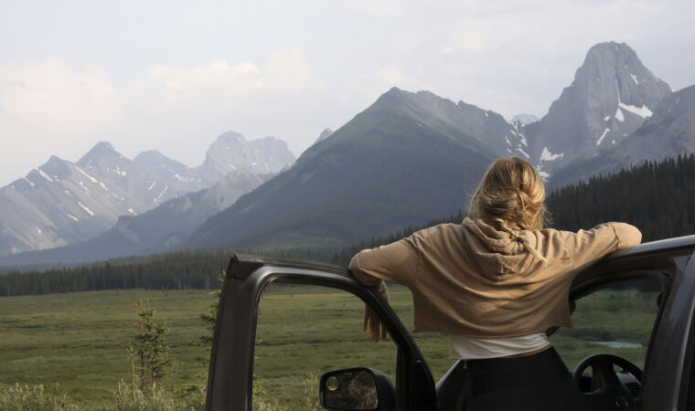 Young woman stops driving to relax and enjoy the view