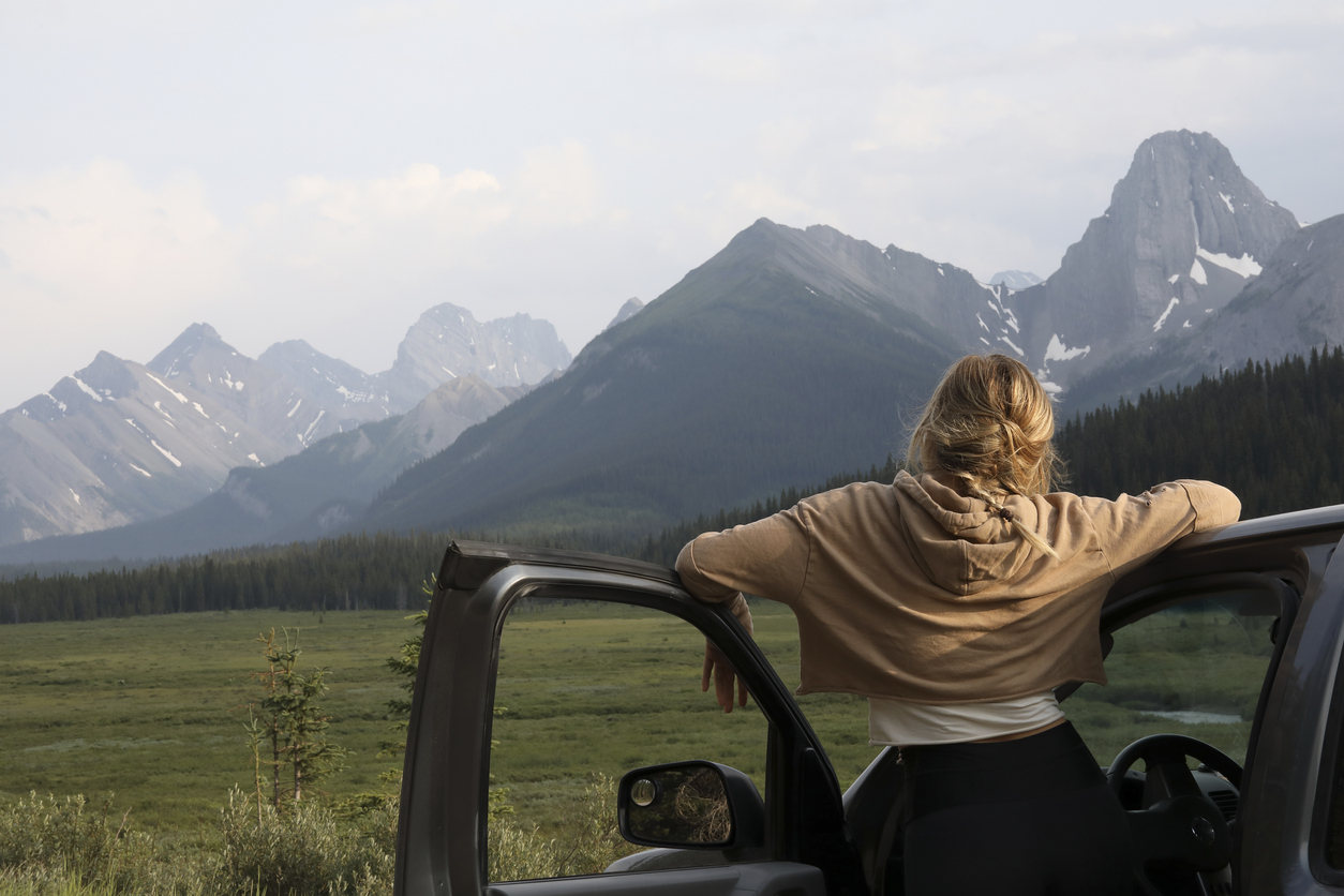Young woman stops driving to relax and enjoy the view